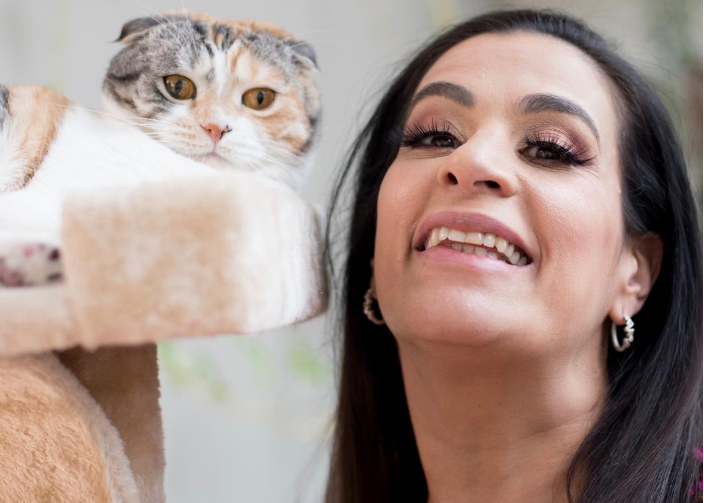 Maysoon smiling next to her cat, Beyonce