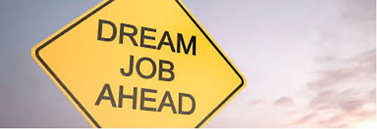 Image is of a traffic sign with the words “Dream Job Ahead” written on it. A purple-pink sunset sky is in the background.
